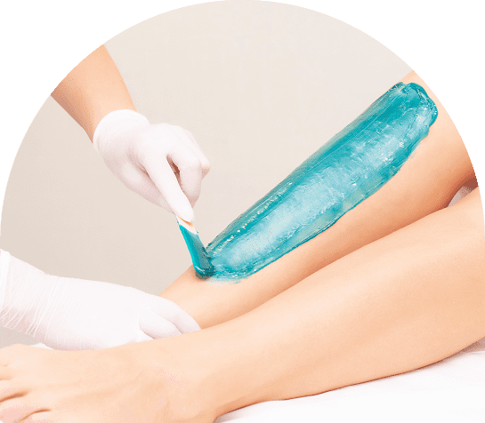 Applying blue wax on woman's leg.