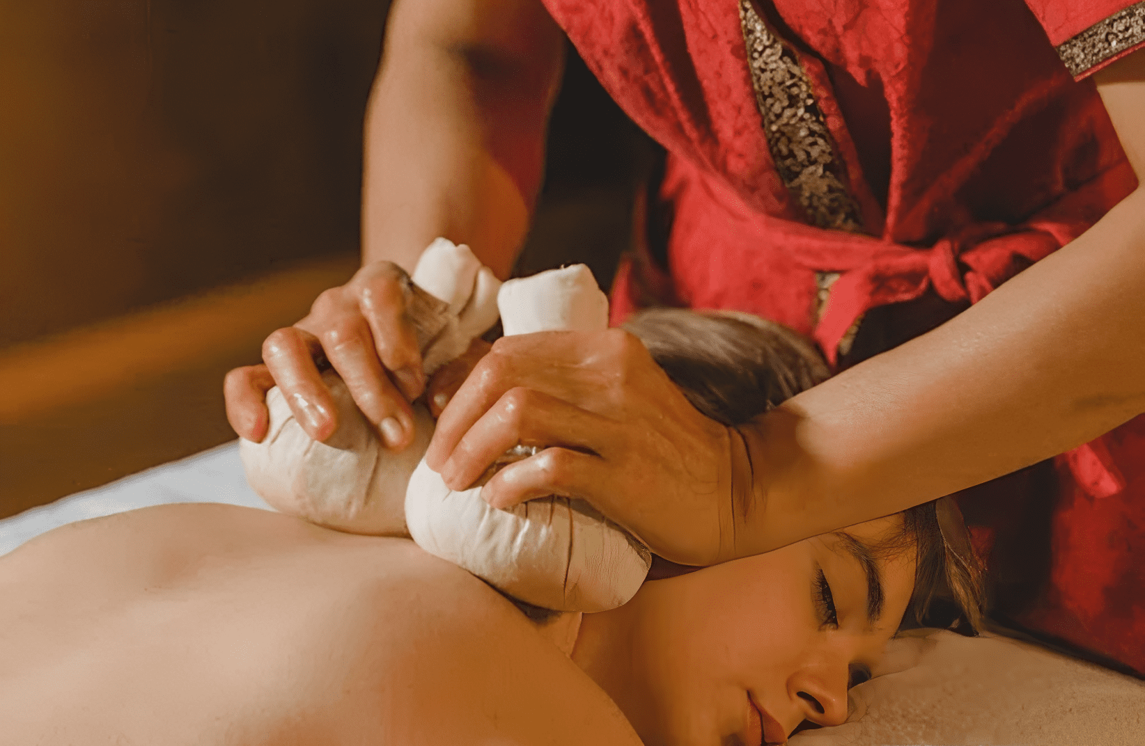 Woman receiving herbal massage therapy